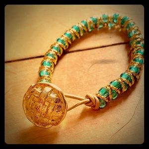 A teal and gold button up bead bracelet.